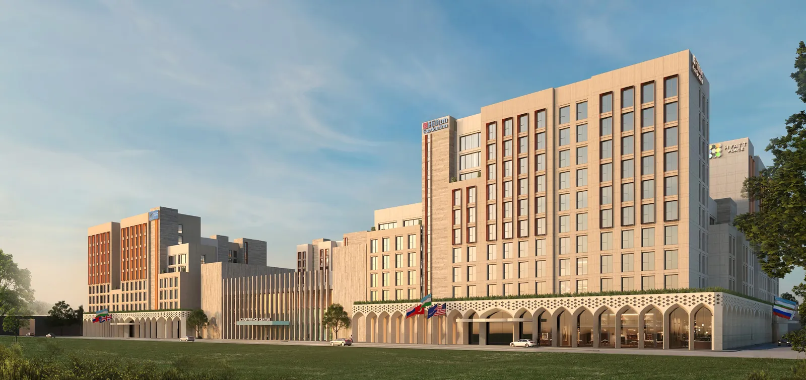 Terracotta-toned hotel building with an arcaded base, seen at dusk