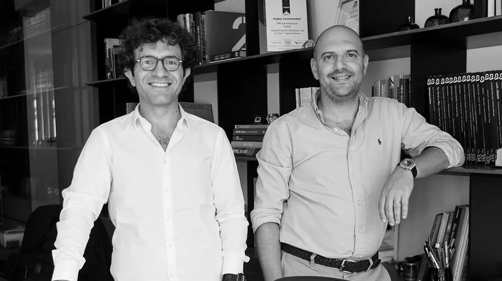 Black-and-white portrait of the two founders, Emre Özer and Tayfun Tulgan, in their studio